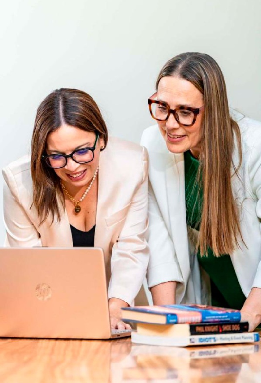 Ivelis and a client reviewing work together at a computer monitor